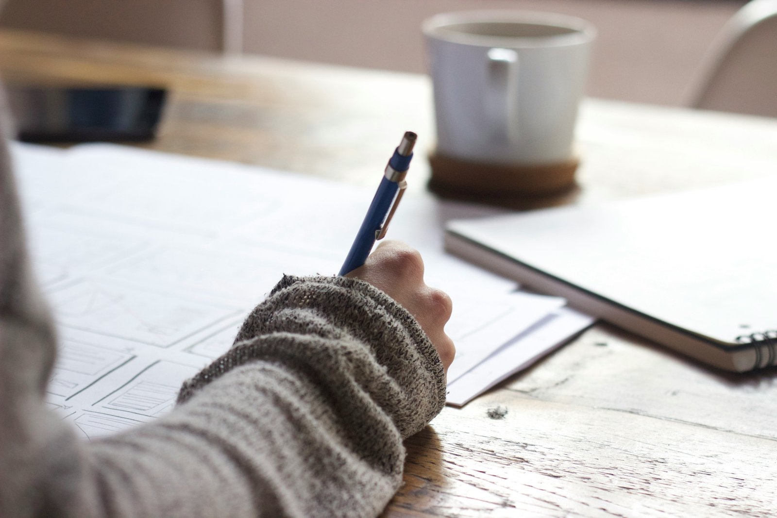 A writer working at a desk during a careful manuscript review
